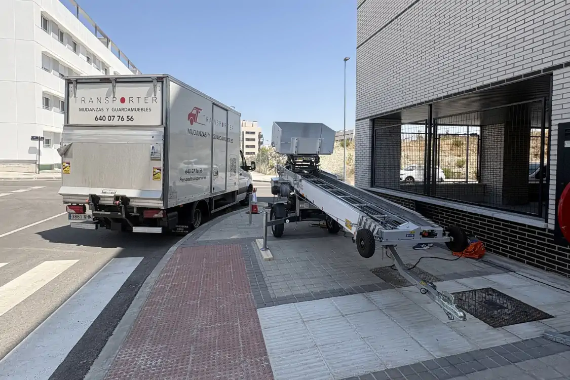 Camión de mudanzas de Transporter junto al elevamuebles propio